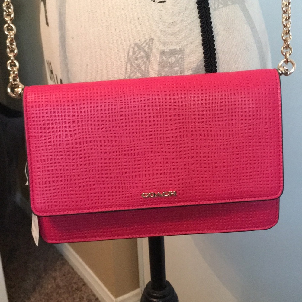 This is a Coach bright pink crossbody handbag